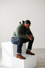 Fashionable Black Man Sitting And Praying Indoor