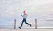 © Courtney H/peopleimages.com - Senior woman running outdoor at on sky mockup at beach promenade for energy, health and cardio workout. Elderly female, exercise and runner at ocean for sports training, fitness and healthy marathon