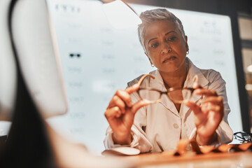 Poster - Glasses, optometry and check with a mature woman optician looking at a pair of frame spectacles in the office. Eyewear, healthcare and examine with a female optometrist checking prescription lenses