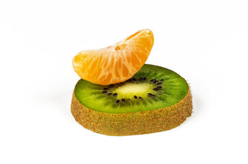 Close-up of mandarin slices and kiwi slices on a white background