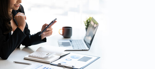 Wall Mural - Happy businesswoman using mobile phone sitting at desk office, copy space.