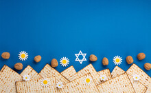 Passover Greeting Card With Matzah, Nuts And Spring Flowers On Blue Background.