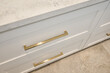 closeup angled view of cabinet drawers with gold hardware and stone countertop