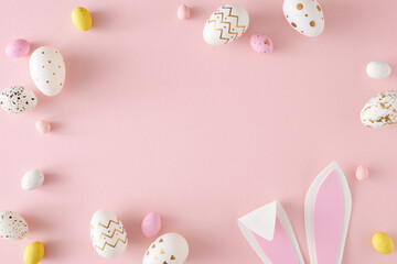 Wall Mural - Easter party concept. Flat lay photo of yellow pink white eggs easter bunny ears on isolated pastel pink background with empty space. Holiday card idea