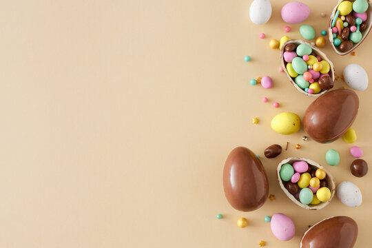 easter sweets concept. top view photo of chocolate eggs dragees sprinkles on isolated beige backgrou