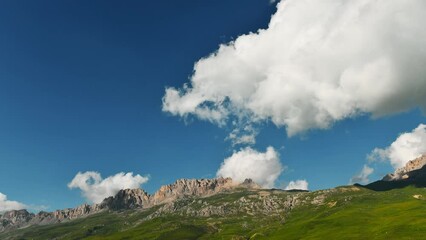 Wall Mural - Clouds over the mountains at sunrise timelapse. Clouds forming and moving over the mountains. Summer landscape. Digor Gorge in North Ossetia, Caucasus, Russia.

