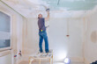 © lara-sh - Worker make repairs in new apartment. Man plaster walls and ceilings. High quality photo