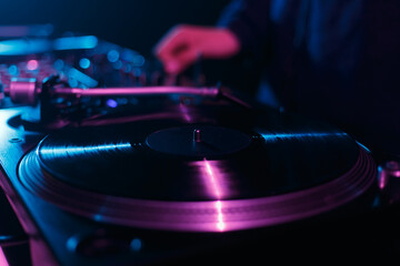 Wall Mural - DJ turntable player playing vinyl record on techno party in dark night club