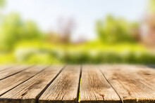 Wooden Table On The Background Of Blurry Trees In The Park In The Summer Season. Sunny Weather.