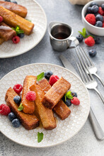 French Toast Sticks Served With Fresh Berries And Maple Syrup