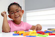 © Arlette - 4-year-old brunette Latina girl with autism spectrum disorder ASD like Asperger, Rett and Heller draws at a desk, plays with colors alone antisocial