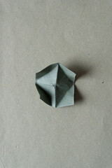 Sticker - dark green paper square with roughly folded corners (turned upwards)