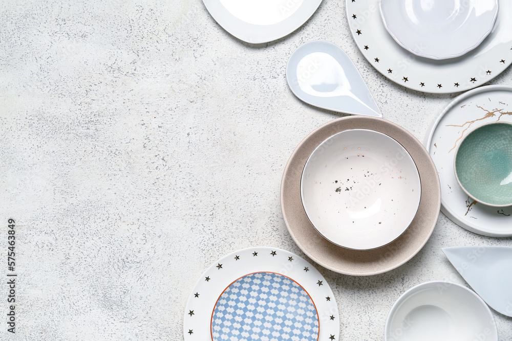 Composition with clean ceramic plates and bowls on white background