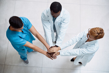 Canvas Print - Doctor, meeting and hands together above for collaboration, healthcare or teamwork unity in trust. Top view of doctors piling hand in medical agreement, strategy or partnership for team solidarity