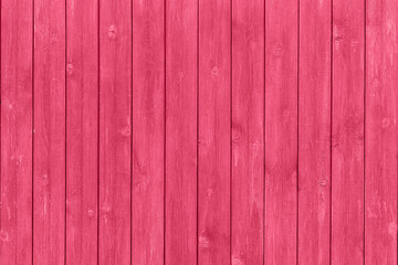 Trendy color of the year 2023. Wooden planks boards, vertical pattern, toned in viva magenta color as background or texture
