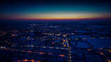 Fototapeta  - Flight over a city illuminated by a sunset flare. City lantern lights from above. A small town from above. Selective soft focus