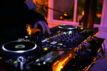 Wall Mural - DJ girl playing music on party in night club. Hands of female disc jockey mixing musical tracks with sound mixer and cd turntables