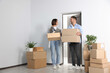 © New Africa - Happy couple with moving boxes entering in new apartment