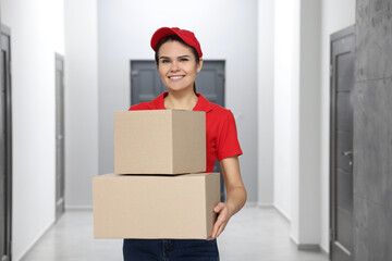 Poster - Smiling courier with cardboard boxes in hallway