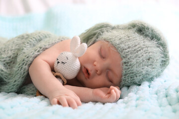 Wall Mural - Cute newborn baby with toy sleeping on soft blanket, closeup