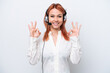 © luismolinero - Telemarketer Russian girl working with a headset isolated on white background showing an ok sign with fingers