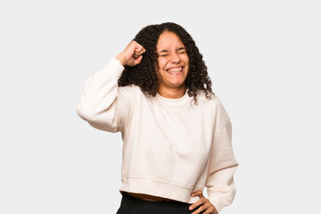 Wall Mural - Young african american curly woman isolated celebrating a victory, passion and enthusiasm, happy expression.