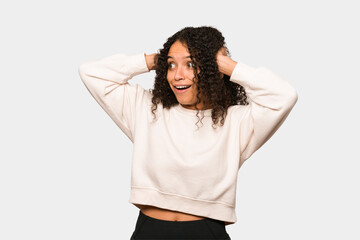 Wall Mural - Young african american curly woman isolated screaming, very excited, passionate, satisfied with something.