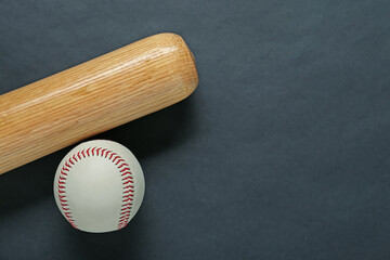 Wooden baseball bat and ball on black background, flat lay. Space for text