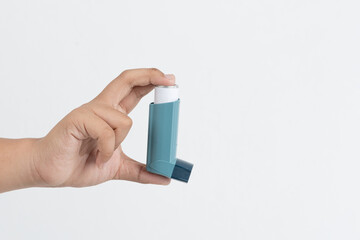 Asian boy hand holding asthma inhaler on white background with space for text