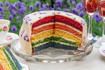 Canvas Print - Multi layered rainbow cake set on garden table - outdoor dining