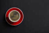 Fototapeta Mapy - Red ceramic cup with hot aromatic coffee on black background, top view. Space for text