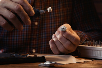 Wall Mural - Professional jeweler working with gemstones at wooden table, closeup