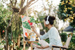 Female artist painting art canvas drawing with inspiration in garden art therapy creativity concept