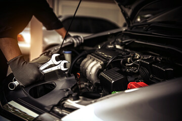 Car care maintenance and servicing, Close-up hand technician auto mechanic using the wrench to repairing change spare part car engine problem and car insurance service support.