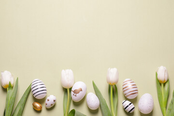 Wall Mural - Flat lay composition of painted Easter eggs and tulip flowers on light green background. Space for text