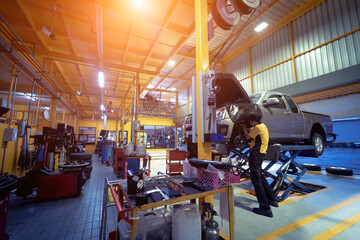 Wall Mural - Car on hydraulic lift in auto repair shop