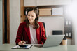 © Nuttapong punna - Confident Asian woman with a smile standing holding notepad and tablet at the modern office.