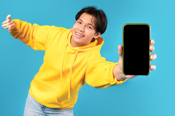Asian Teenager Boy Showing Smartphone Blank Screen On Blue Background