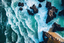Spectacular Drone Photo, Top View Of Seascape Ocean Wave Crashing Rocky Cliff With Sunset At The Horizon As Background. Beautiful Coastal Scenic Landscape With Turquoise Water Beating Rocky Boulder.
