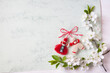 Blooming branches of cherry plum, paper, decor red-white martenitsa symbol of the spring holiday on March 1, Martisor, Baba Marta, wooden background, copy space, congratulations.