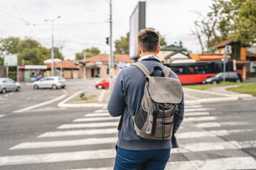 Wall Mural - one young adult man student or tourist hold cup of coffee at crosswalk