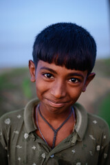 portrait of a South asian poor rural teenage boy wearing t shirt 