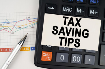 Wall Mural - On the business chart lies a pen, a calculator and a business card with the inscription - Tax Saving Tips