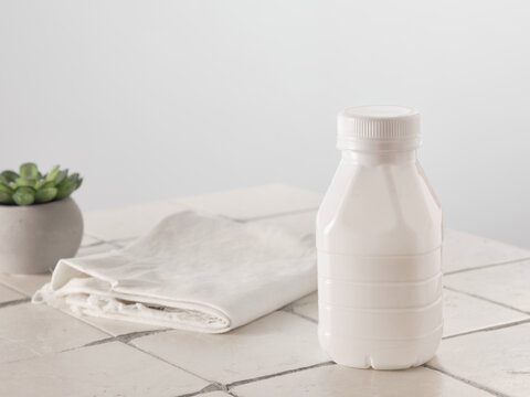 Fototapete - Plastic bottle of milk on gray wall background