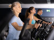 © JackF - Focused mature woman using elliptical machine in gym