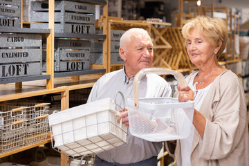 Wall Mural - Mature married couple makes choice of buying a basket for a country house