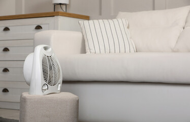 Canvas Print - Electric fan heater on pouf in living room