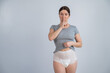 © Михаил Решетников - The woman is wearing adult diapers. Urinary incontinence problem. Finger on lips - silent gesture.
