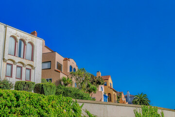 Canvas Print - Homes with arched windows against blue sky in San Francisco California. Beautiful facade of houses with cloudless sky background at a sunny neighborhood.