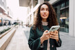 © fotofabrika - Young woman reading a message or using the phone in the city